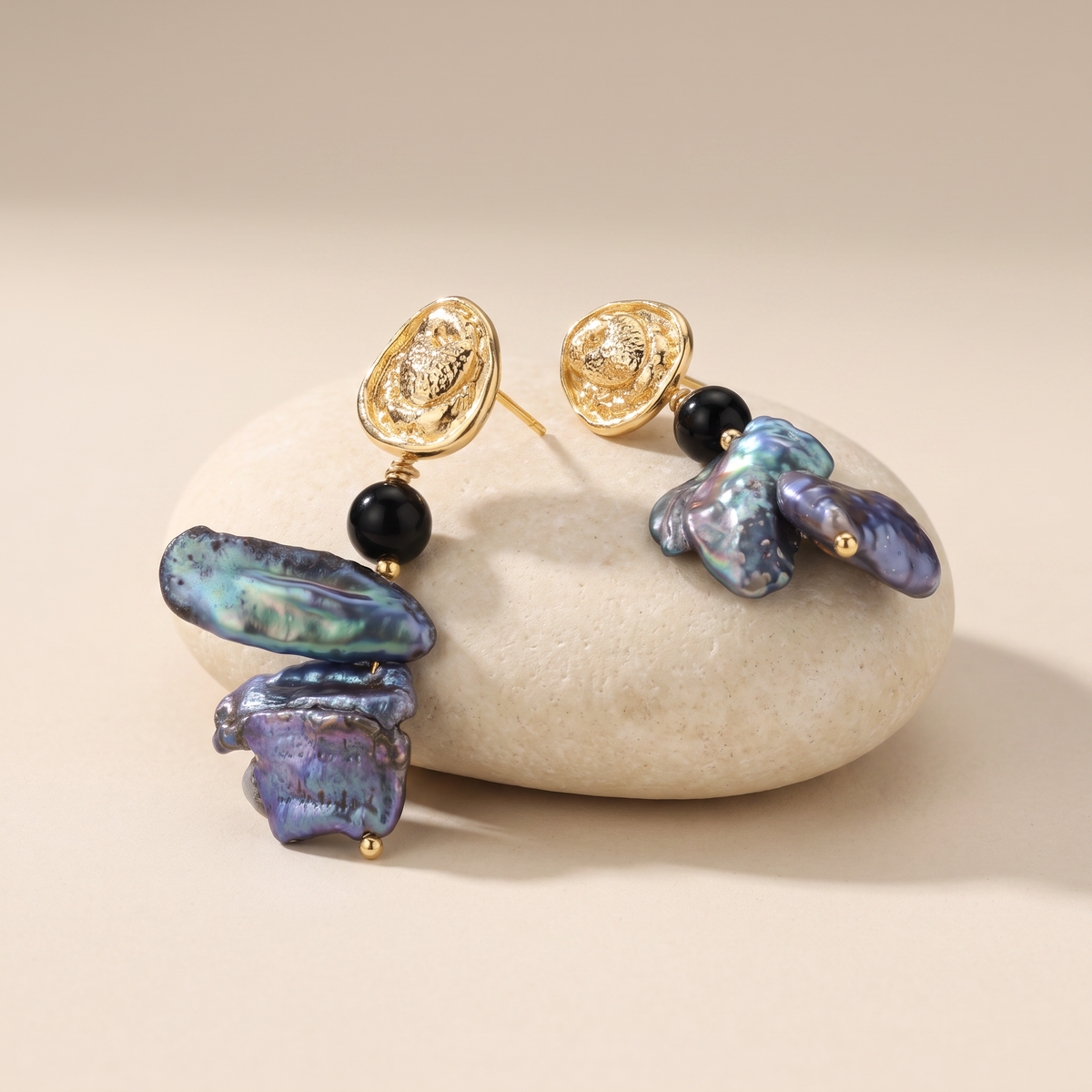Deepwater Pearl earrings resting on a pale stone