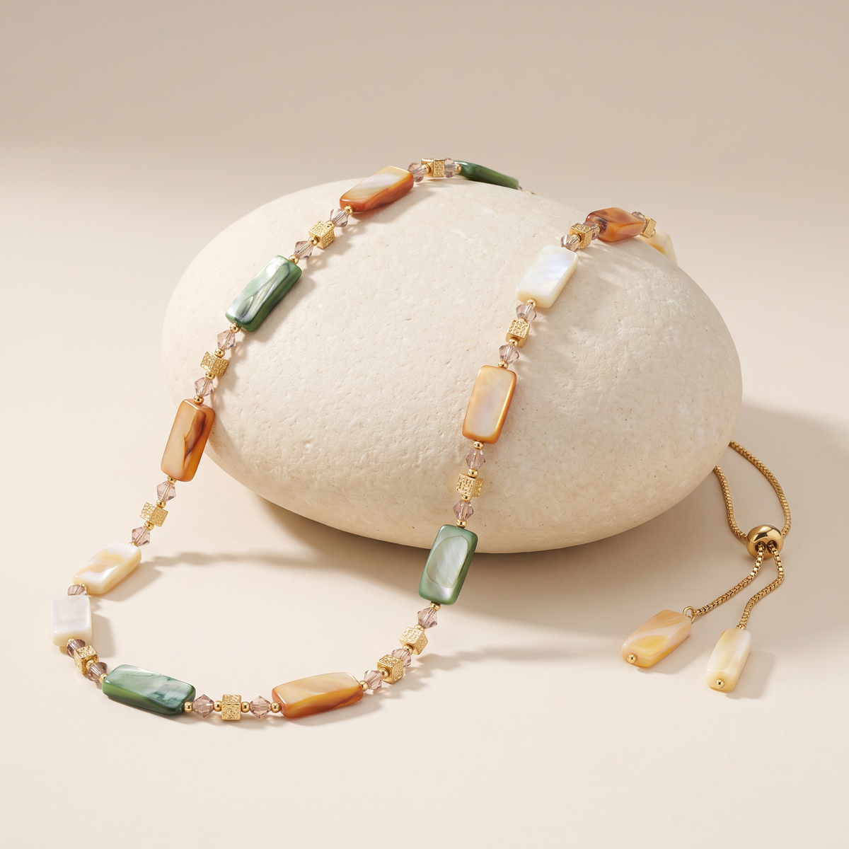 Armour necklace resting on a pale stone