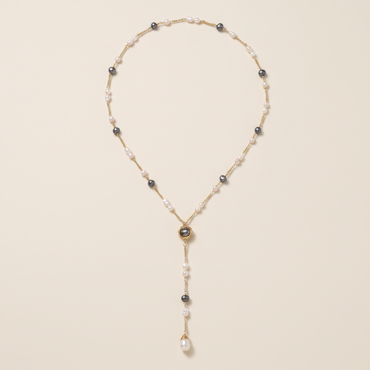 Evening Hour lariat necklace laid flat, white and grey pearls with a wire-wrapped pearl drop