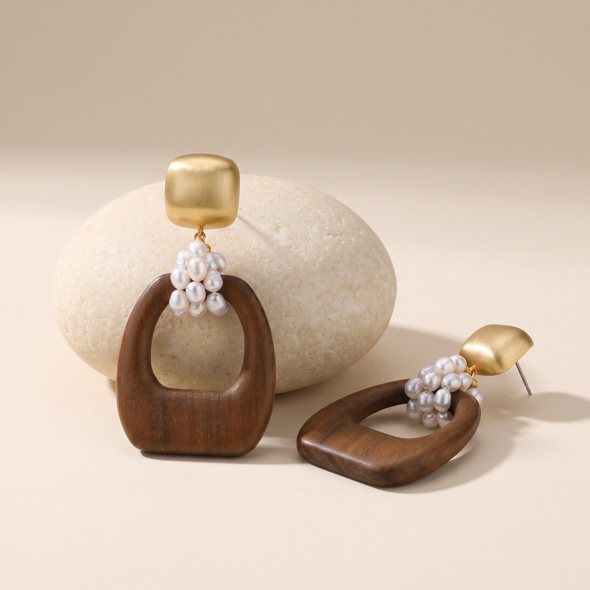 Heartwood earrings resting on a pale stone