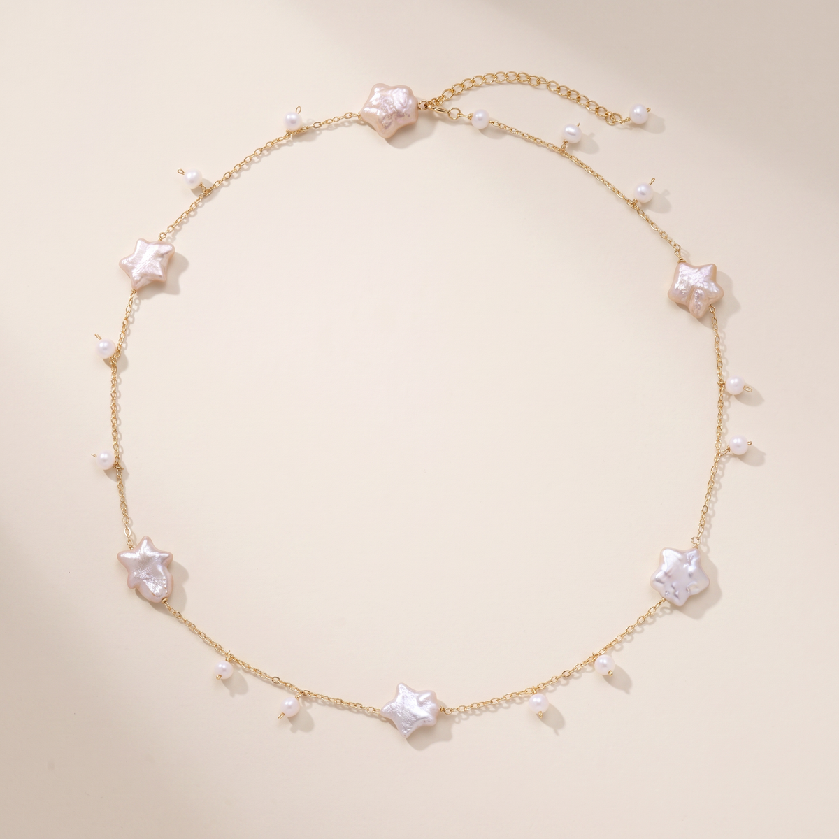 Night Passage necklace laid flat, star-shaped baroque pearls on a fine gold chain