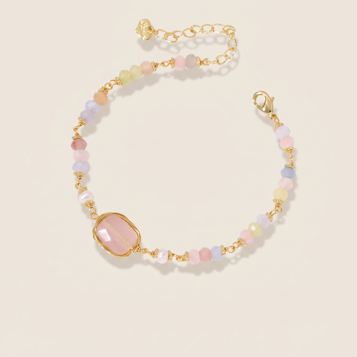 Still Water bracelet laid flat, pastel faceted beads with a rose quartz centrepiece and freshwater pearls