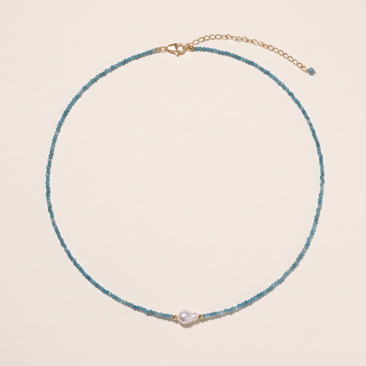 Tidewater necklace laid flat, full strand of teal apatite with a single freshwater pearl